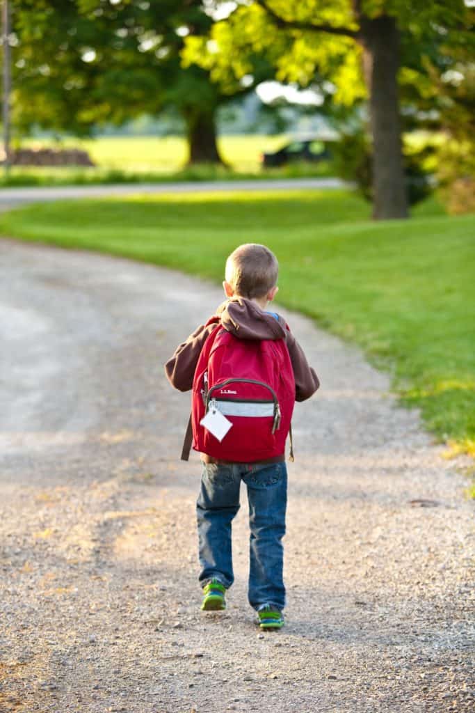 Preschooler carrying a backpack.
