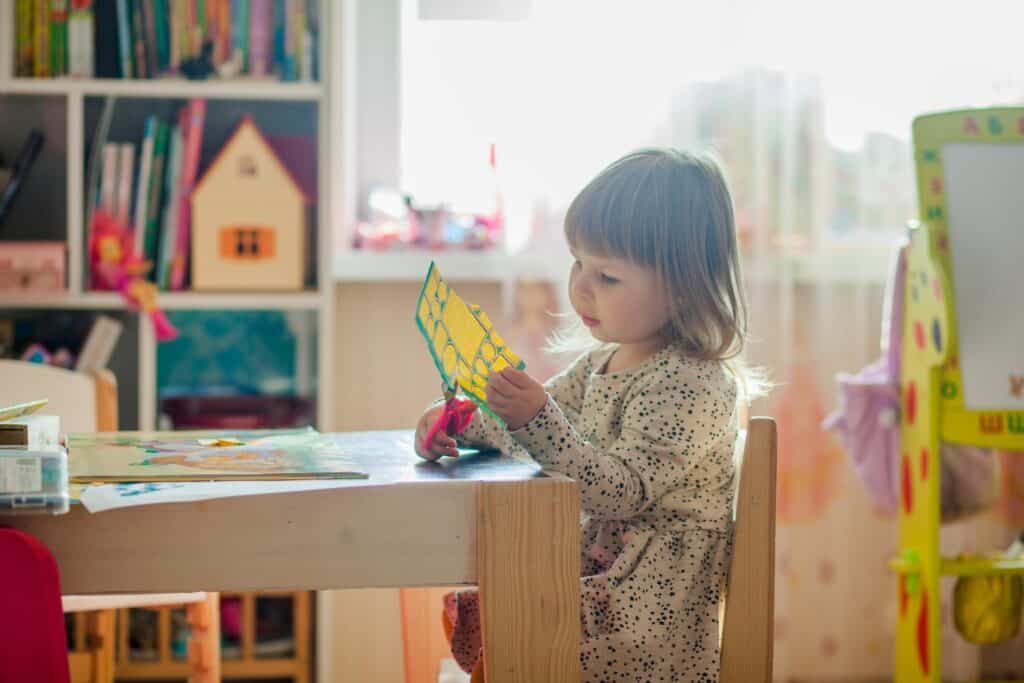 Preschooler cutting paper.