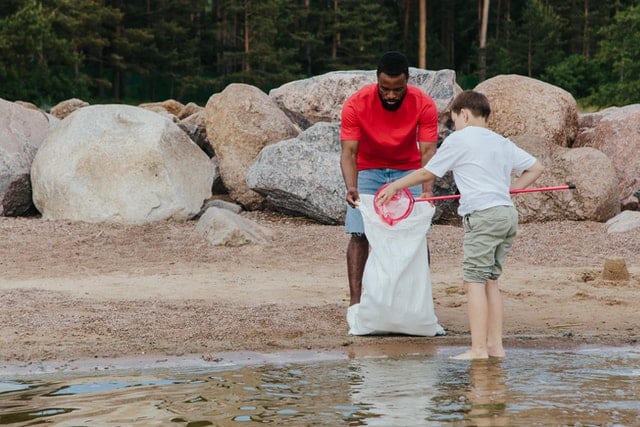 Student and teacher picking up garbage at the beach - photo by Ron Lach from Pexels